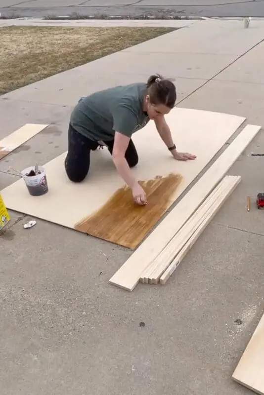 Applying stain to plywood.